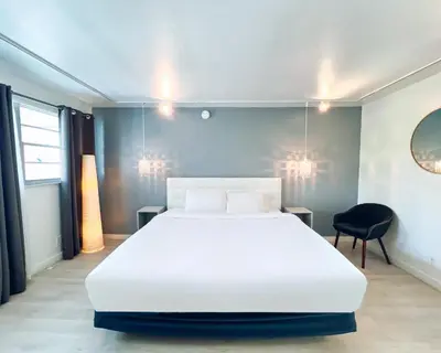 a bedroom with a large white bed and a chair at North Beach Hotel in Fort Lauderdale