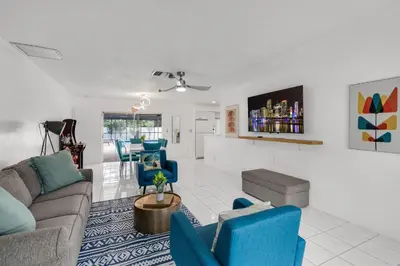 a living room with a couch and blue chairs at Stunning 4BR Oasis with Pool, 14 minutes to the Ocean in Hollywood