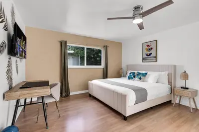 a bedroom with a bed and a desk and a window at Stunning 4BR Oasis with Pool, 14 minutes to the Ocean in Hollywood