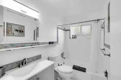 a white bathroom with a toilet and a sink at Stunning 4BR Oasis with Pool, 14 minutes to the Ocean in Hollywood