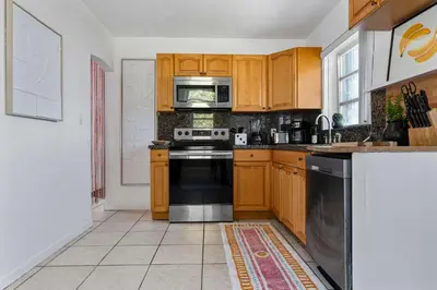 a kitchen with wooden cabinets and a stove top oven at Retro Rewind - Location parking and all the vibes in Miami