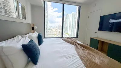 a bedroom with a large bed with a large window at Stylish One Bedroom in the heart of vibrant Downtown- Daily resort fee and parking not included in Miami