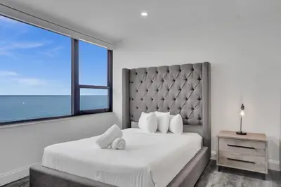 a bedroom with a large bed with a large window at Luxury 2BD Penthouse with Beach Access and Resort Amenities PH6 in Miami Beach