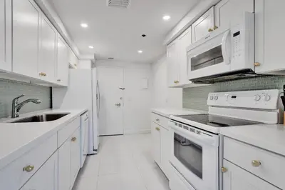a white kitchen with white appliances and a sink at Luxury 2BD Penthouse with Beach Access and Resort Amenities PH6 in Miami Beach