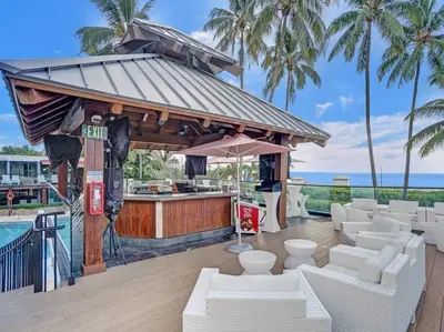 a bar with white furniture and a swimming pool at Beautiful Oceanview Condo 2 Bedrooms, 2 Bathrooms with Beach Service 709 in Miami Beach