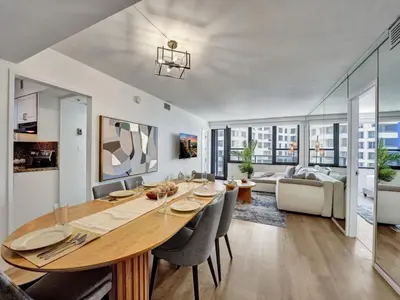 a dining room and living room with a table and chairs at Beautiful Oceanview Condo 2 Bedrooms, 2 Bathrooms with Beach Service 709 in Miami Beach