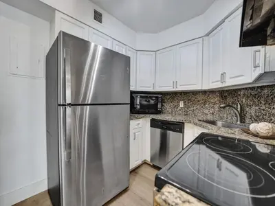 a stainless steel refrigerator in a kitchen with white cabinets at Beautiful Oceanview Condo 2 Bedrooms, 2 Bathrooms with Beach Service 709 in Miami Beach