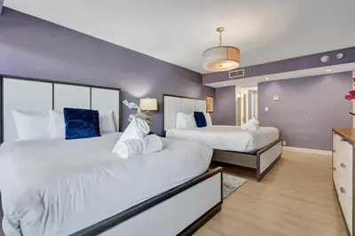 two beds in a room with purple walls at 2 Bedroom Condo with Resort Amenities, Pool and Gym 618 in Miami Beach