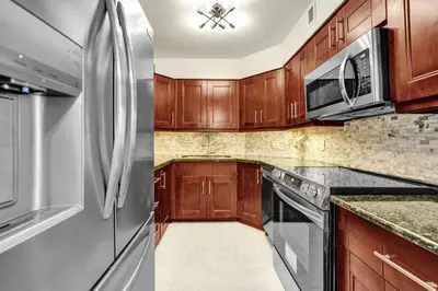 a kitchen with wooden cabinets and a stainless steel refrigerator at Comfortable 2-Bedroom Condo Retreat with Resort Facilities 1108 in Miami Beach