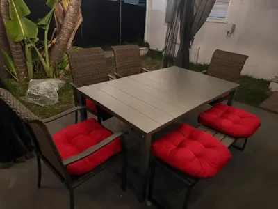 a table and chairs with red cushions at 2-bed Lakeridge Fllfree Parking 6 Min To Beach in Fort Lauderdale