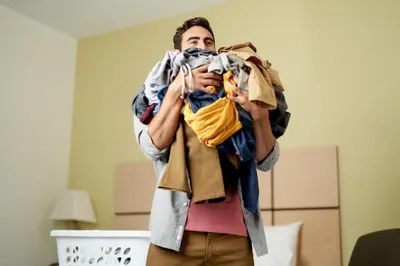 a man is holding a pile of clothes at Candlewood Suites Miami - Doral by IHG in Tamiami