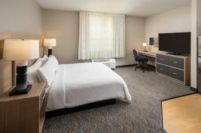 a hotel room with a bed and a desk and a television at Candlewood Suites Miami - Doral by IHG in Tamiami