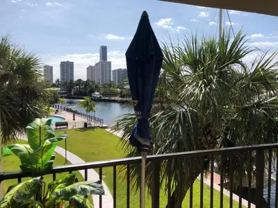 an umbrella on a balcony with a view of a city at Golden Isles Suite 315 in Hallandale Beach
