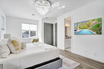 a white bedroom with a bed and a chandelier at The Secret Garden - Stunning Luxurious Villa in Fort Lauderdale in Fort Lauderdale