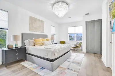 a white bedroom with a bed and a desk at The Secret Garden - Stunning Luxurious Villa in Fort Lauderdale in Fort Lauderdale