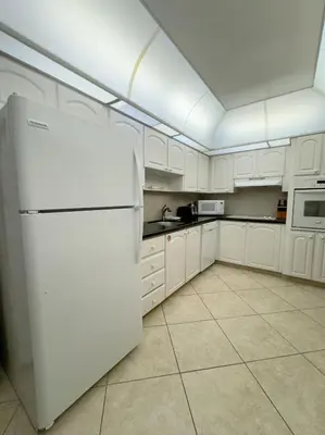 a kitchen with white cabinets and a white refrigerator at Spectacular ocean view 1 bedroom in Hollywood in Hollywood