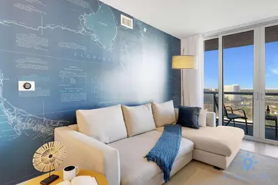 a living room with a white couch and a blue wall at Modern Stylish 2BR with Balcony in Hallandale Beach