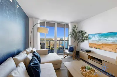 a living room with a couch and a tv at Modern Stylish 2BR with Balcony in Hallandale Beach