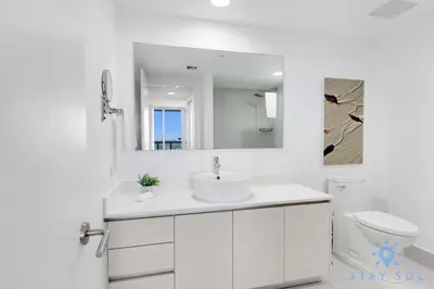 a white bathroom with a sink and a mirror at Modern Stylish 2BR with Balcony in Hallandale Beach