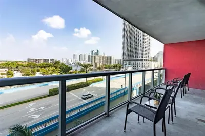 a balcony with chairs and a view of the city at Luxury Suite on Beachwalk with Pool Gym & Beach in Hallandale Beach
