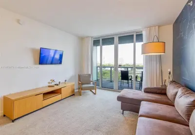 a living room with a couch and a tv at 2 Bed 2 Bath at Beachwalk with Luxury Pool and Gym in Hallandale Beach