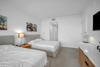 a bedroom with two beds and a flat screen tv at Luxury 2BR-2BA Condo on 30th Floor with Epic Views in Hallandale Beach