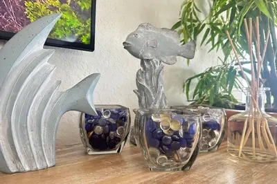 a table with three glass vases and a fish statue at Oceanfront Villa On Semi-Private Holywood Beach in Hollywood