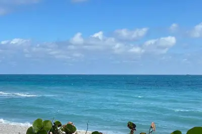 a group of people standing on a beach near the ocean at Cozy studio in Hollywood, FL in Hollywood