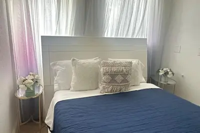 a bedroom with a blue and white bed with pillows at Gorgeous 4-bedroom beach space in Hollywood