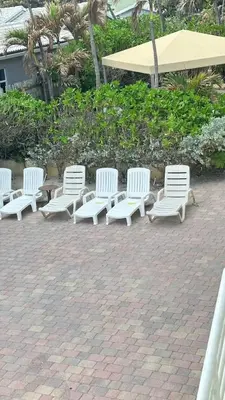 a row of white benches and an umbrella at Gorgeous 4-bedroom beach space in Hollywood