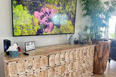 a large painting on a wall above a wooden dresser at Gorgeous 4-bedroom beach space in Hollywood