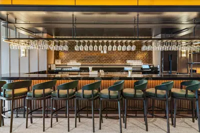 a bar with green bar stools in a restaurant at Suite at downtown Miami residences - Great view 30th floor in Miami