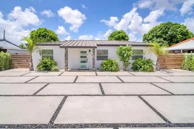 a white house with a patio in front of it at 5 Bedroom Home Location & Charm in Miami