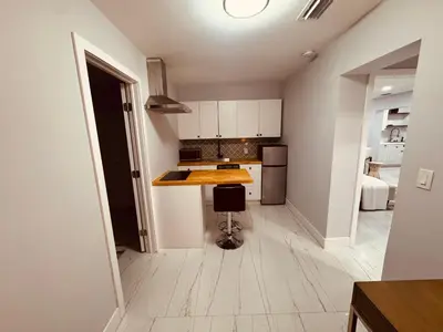 a kitchen with white cabinets and a wooden counter top at 5 Bedroom Home Location & Charm in Miami