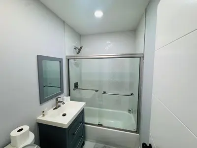 a bathroom with a glass shower and a sink at 5 Bedroom Home Location & Charm in Miami