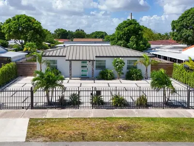a house with a fence in front of it at 5 Bedroom Home Location & Charm in Miami