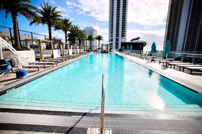 a swimming pool with chaise lounges and palm trees at 42nd Floor Penthouse 3 BDR in Hyde Beach House in Hollywood