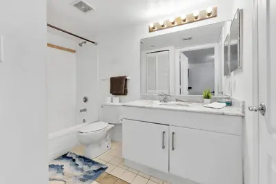 a white bathroom with a toilet and a sink at Luxury Miami Brickell Stay-Bay View in Miami