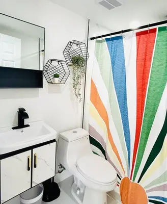 a bathroom with a toilet and a shower curtain at Chic Comfortable Boutique Stay in Miami