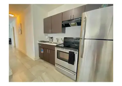 a kitchen with a stainless steel refrigerator and wooden cabinets at 2bed Stay in the Heart of Miami in Miami