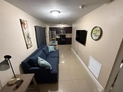 a living room with a blue couch and a kitchen at 1Bed Abode Near Main Attractions in Miami