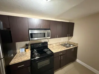 a kitchen with a black stove and a microwave at 1Bed Abode Near Main Attractions in Miami
