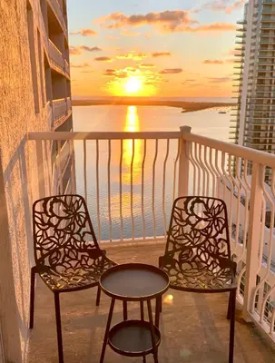 two chairs and a table on a balcony with a sunset at Best views, 2 balconies, 2 bedrooms, pool, gym, parking in Miami