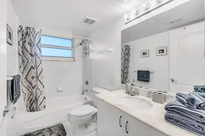 a white bathroom with a sink and a tub and a toilet at Best views, 2 balconies, 2 bedrooms, pool, gym, parking in Miami