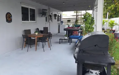 a patio with a piano and a table and chairs at Luxury 3BR Duplex in Cutler Bay, Pool Table, BBQ, Terrace & Free Parking in Cutler Ridge