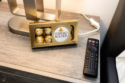 a box of chocolates on a table next to a remote control at Best Room in Miami ! in Miami