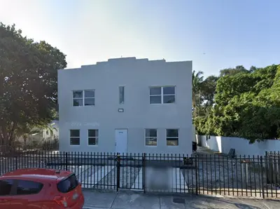 a white house with a red car parked in front of it at Prime Location Near Wynwood in Miami