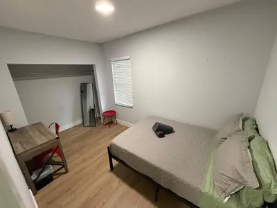 a bedroom with a bed and a table and a chair at Perfect Central Stay in Miami