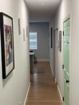 a hallway with doors and paintings on the walls at Stay Near Wynwood in Miami