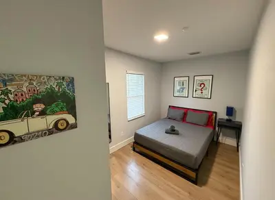 a bedroom with a bed and a painting of a car at Stay Near Wynwood in Miami